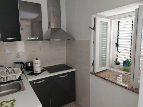 eine kleine Küche mit einem Waschbecken und einem Fenster in der Unterkunft Studio Apartment Klaric in Vis