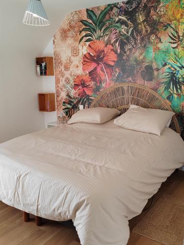 - une chambre avec un grand lit et un mur fleuri dans l'établissement L'Oté de Brekilien, à Saint-Malon-sur-Mel