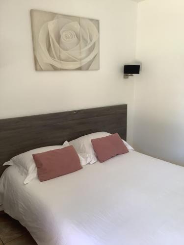 a white bed with two pillows on top of it at la dolce farniente in Biaudos