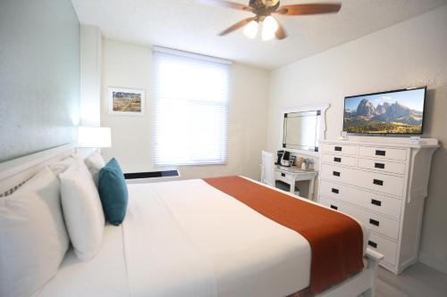 1 dormitorio blanco con 1 cama y ventilador de techo en Hotel Carmel Santa Monica, en Los Ángeles