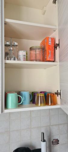 a kitchen shelf with cups and bowls on it at La casa Ciarlasca in Lacchiarella