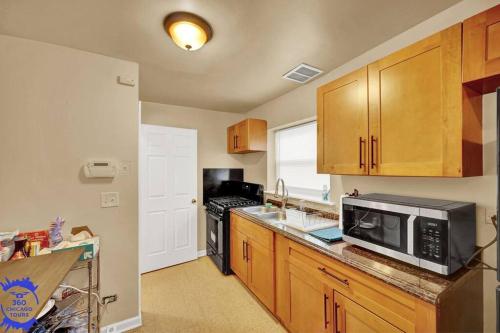 a kitchen with wooden cabinets and a microwave at The Katerina Residence in Calumet City