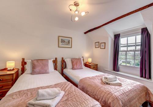 a bedroom with two beds and a window at Rose Cottage in Chapel Stile