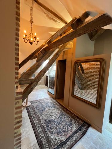 a hallway with wooden beams and a chandelier at Charnay Plaisance, piscine, les chambres du chocolatier Daniel Mercier in Vierzon
