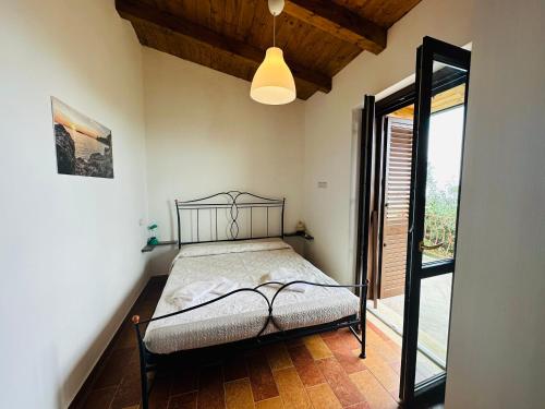 a bedroom with a bed and a large window at Villetta Starza in Marina di Camerota