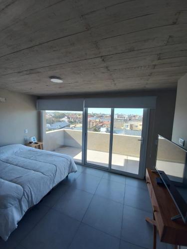 a bedroom with a bed and a large window at Depto Los Pinos in Ostende