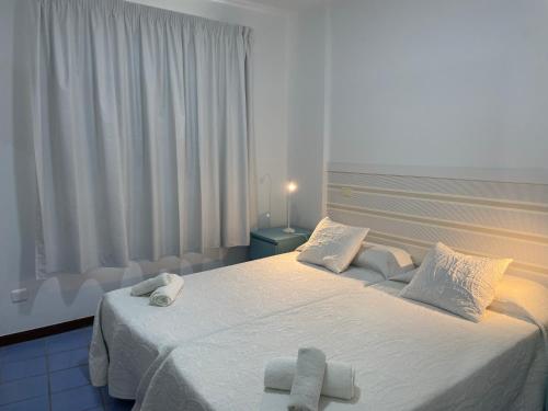 ラスパルマス・デ・グランカナリアにあるLa Sal Marina 2Aのベッドルーム1室(ベッド1台、タオル2枚付)