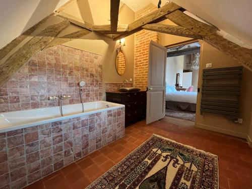 a bathroom with a bath tub and a bedroom at Domaine de Charnay Plaisance Sologne in Vierzon