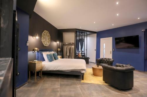 una camera da letto con un letto e una parete blu di Le Legendary Spa, hypercentre avec sauna, balnéo et wifi par SOVALFI a Saint-Étienne
