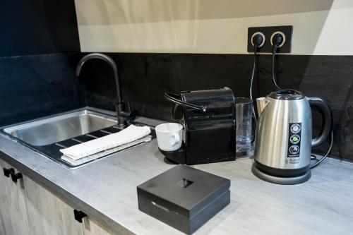 a kitchen counter with a sink and a coffee maker at Le Legendary Spa, hypercentre avec sauna, balnéo et wifi par SOVALFI in Saint-Étienne