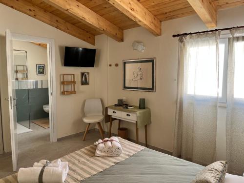 a bedroom with a bed and a desk and a bathroom at B&b AlgueRoof in Alghero
