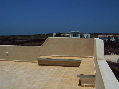 a bench on the side of a building with a blue sky at Casa Oscar in El Roque