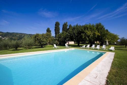 a large swimming pool with lounge chairs and trees at Villa dell'Ovo in Brisighella