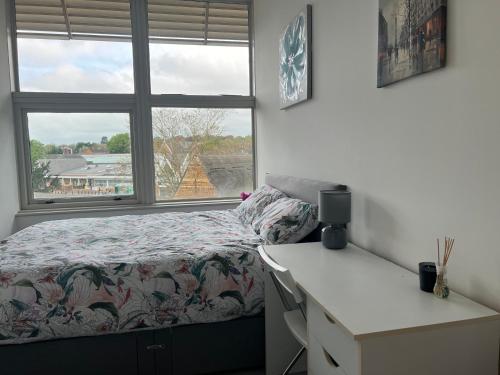 1 dormitorio con cama y ventana en 3 Bedroom Flat in Town Centre en Wellingborough