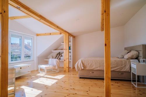 an attic bedroom with a bed and a window at Villa Alenor Nessebar in Nesebar