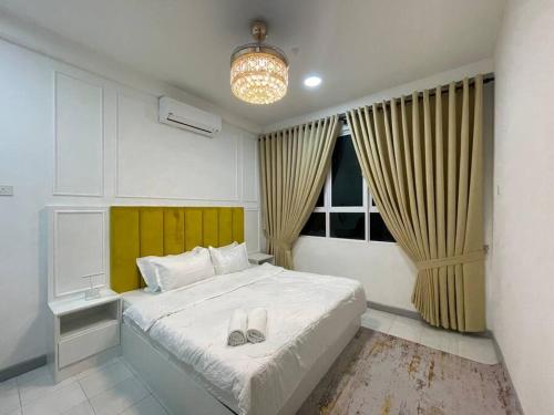a bedroom with a bed with two slippers on it at 4 Bedroom SeaView Ladang Tanjung Apartment - Ayla Homestay in Kuala Terengganu