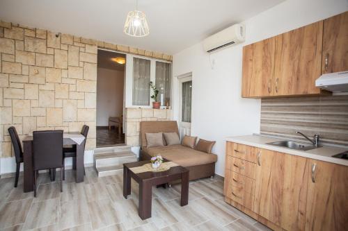 a kitchen and a living room with a couch and a table at Apartments Jelena Ulcinj in Ulcinj