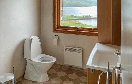 a bathroom with a toilet and a sink and a window at Lovely Apartment In Sandnes With House Sea View in Forsand