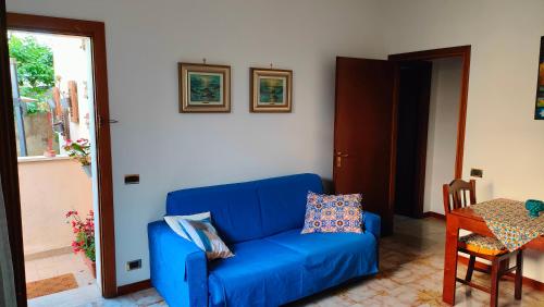 a blue couch in a living room with a table at GreenHouse_Anzio in Anzio