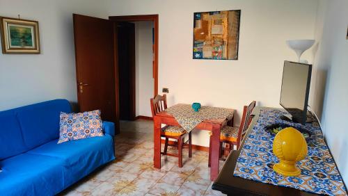 a living room with a blue couch and a table at GreenHouse_Anzio in Anzio