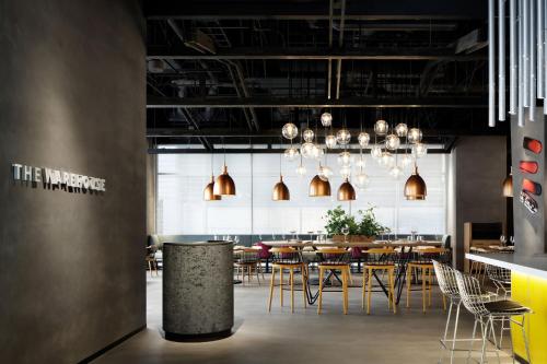a dining room with tables and chairs and chandeliers at Aloft Osaka Dojima in Osaka