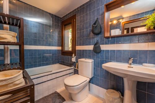 Baño de azulejos azules con aseo y lavamanos en ST-4 BEGUR SA TUNA 4 PAX, en Begur