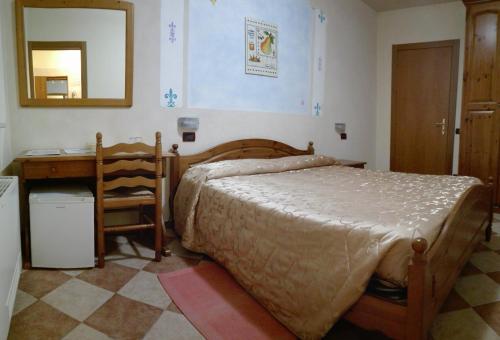 a bedroom with a bed and a desk and a mirror at Agriturismo Ca' Licante in Bardolino