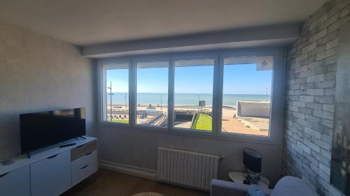 un salon avec une grande fenêtre avec vue sur l'océan dans l'établissement residence du bord de mer 9 appartements avec une vraie vue mer, au Tréport