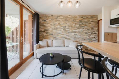 un salon avec un canapé, une table et des chaises dans l'établissement Bel appartement 6 couchages au plan d'eau d'Embrun, à Embrun