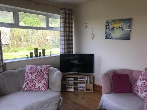 a living room with two couches and a flat screen tv at Rosie's Pad in Mayo
