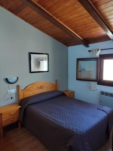 - une chambre avec un lit et un plafond en bois dans l'établissement Casa Enry, à Alcalá de la Selva