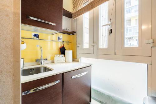 uma cozinha com armários de madeira e um lavatório em Araba Fenice Apartments - Bari Centro em Bari