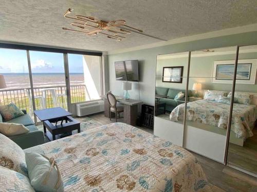 a bedroom with a bed and a view of the ocean at Beachfront Islander East Studio in Galveston