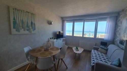 un salon avec une table et un canapé dans l'établissement residence du bord de mer 9 appartements avec une vraie vue mer, au Tréport