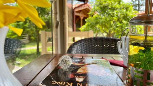 a book on a wooden table with a bottle of juice at Aida Hotel in Cıralı
