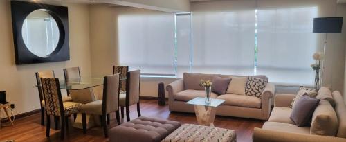 sala de estar con sofá, mesa y sillas en San Martin Apartment Miraflores, en Lima