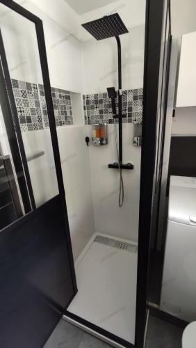 une douche avec une porte vitrée dans une salle de bain dans l'établissement Appartement meublé classé 3 étoiles de 72 m2, 2 chambres, à Morzine