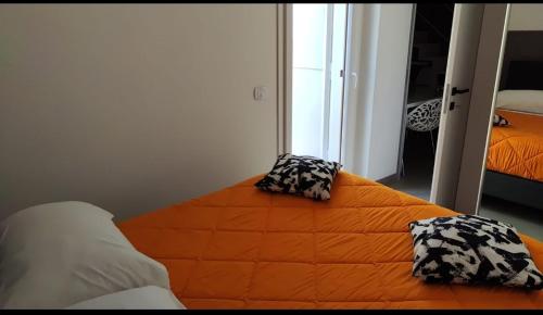 Bett in einem Zimmer mit zwei Kissen darauf in der Unterkunft San Francesco Rooms and Apartment with Terrace in Palermo in Palermo