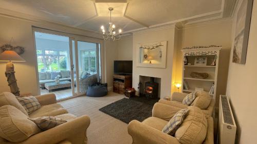 a living room with two couches and a fireplace at Ivy Cottage Seahouses Seaside Hot Tub Retreat in Seahouses