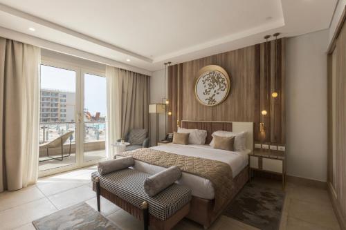 a hotel room with a bed and a large window at Gewan Resort New Alamein in El Alamein