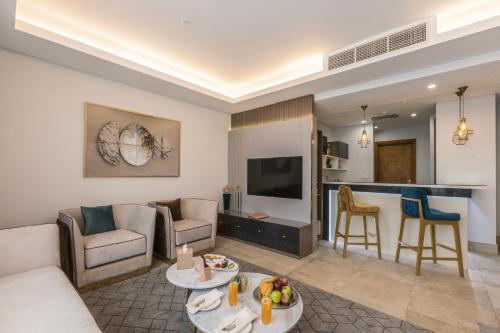 a living room with a couch and a tv and a kitchen at Gewan Resort New Alamein in El Alamein