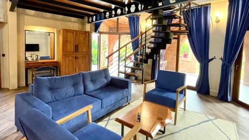 a living room with a blue couch and a staircase at Aida Hotel in Cıralı