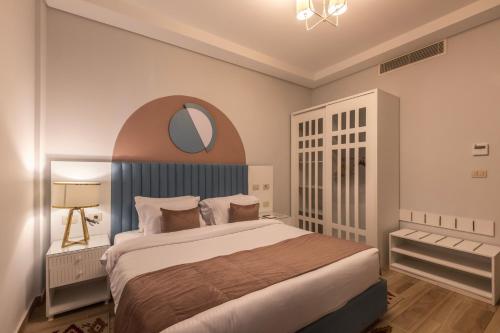 a bedroom with a large bed and a mirror at Gewan Resort New Alamein in El Alamein
