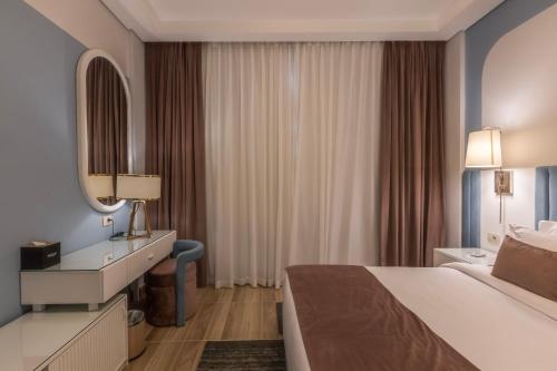 a hotel room with a bed and a mirror at Gewan Resort New Alamein in El Alamein