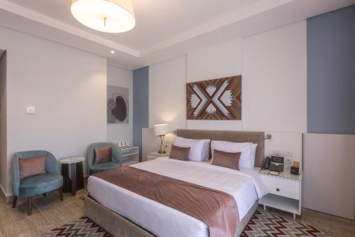 a bedroom with a large bed and two chairs at Gewan Resort New Alamein in El Alamein