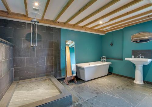 a bathroom with blue walls and a tub and a sink at The Chapel in Silecroft