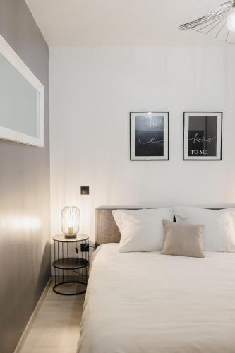 a white bedroom with a large bed and a table at Beau T3 au style moderne #2 in Embrun