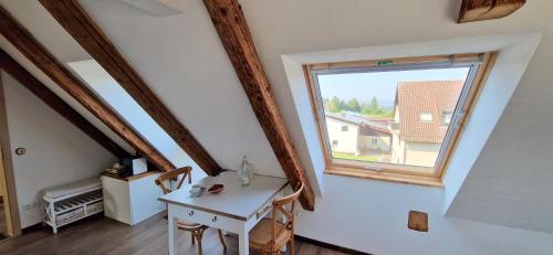 a room with a small table and a window at Waldvogel Ferienzimmer klimatisiert in Immenstaad am Bodensee