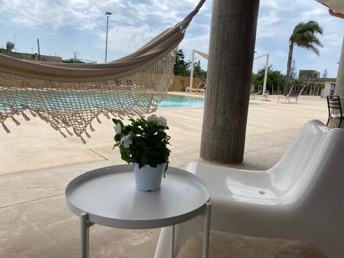 a table with a plant on it next to a hammock at Verde Oliva Residence in Ispica