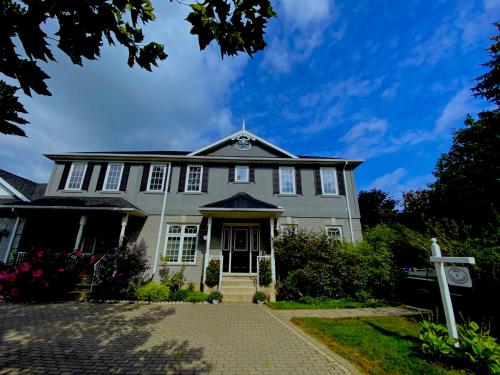 a gray house with a cobblestone driveway at Charlottetown House in Niagara on the Lake